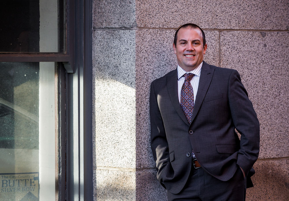 A workers' compensation attorney smiling outside a courthouse, representing clients with personalized, one-on-one legal support.